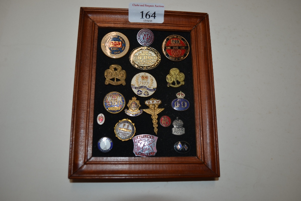 A framed collection of enamel and other badges