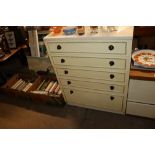 A laminate chest of five gradated drawers