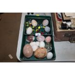 A box containing glass pebbles and decorative eggs