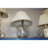 A glass table lamp and shade
