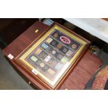 A framed and glazed collection of stamps and coins