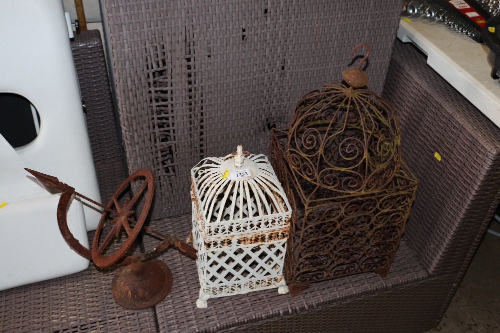 A metal sundial together with two hanging candle l