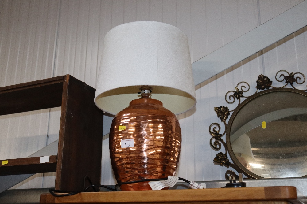 A copper table lamp and shade