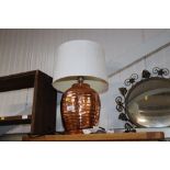 A copper table lamp and shade