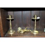 A pair of brass candlesticks and brass cherub orna