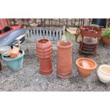 A terracotta chimney pot with one other