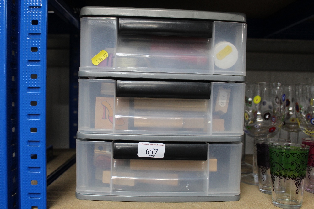 A plastic three drawer storage unit containing var