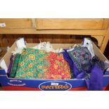 A box containing various fabrics, scarves etc