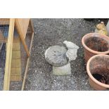 A concrete bird bath decorated with bird