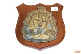 A cast brass plaque featuring a diver holding a su