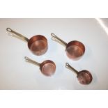 A graduated set of four brass and copper measuring