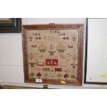 An antique sampler in simulated walnut and gilt fr