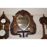 An Edwardian carved mahogany mirrored wall shelf