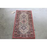 An approx. 3'9" x 2' red patterned rug