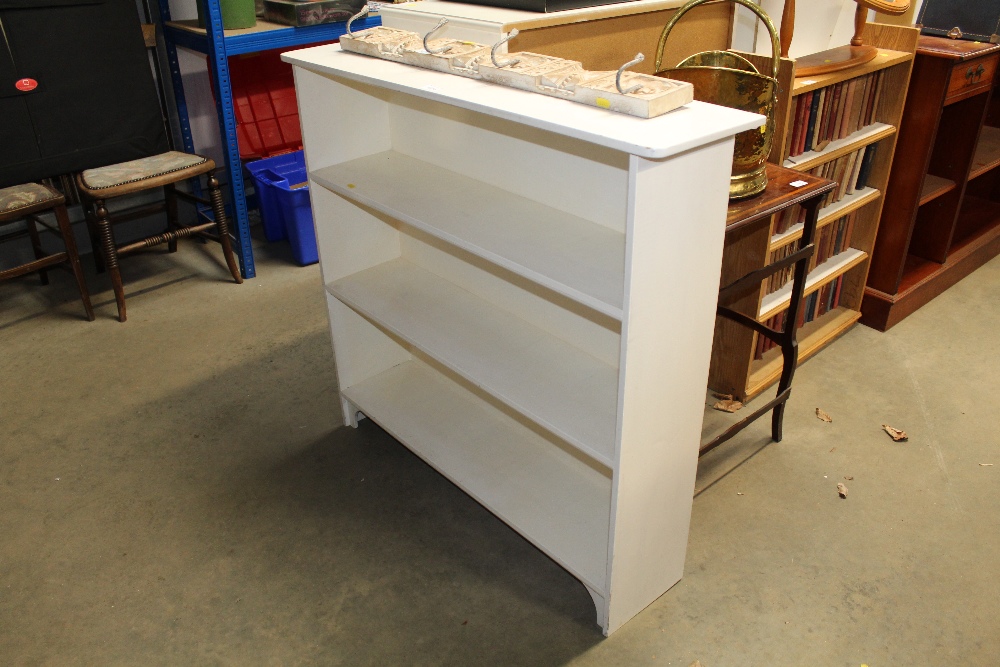 A white painted open fronted bookcase