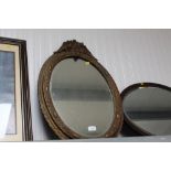 An oval gilt framed mirror