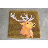An approx. 2'5" x 2'4" rug decorated with a stag