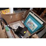 A box of miscellaneous prints and a Polaroid camer