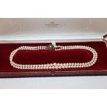 A 9ct gold and garnet set clasped pearl necklace
