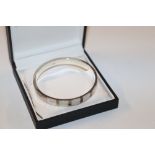 A mother of pearl set silver hinged bangle