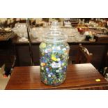 A plastic jar of various marbles