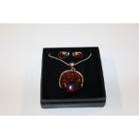 A sterling silver and amber set pendant, hung to s