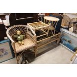 A cane and glass topped coffee table; a side table