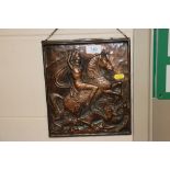 A bronzed plaque depicting George and the Dragon