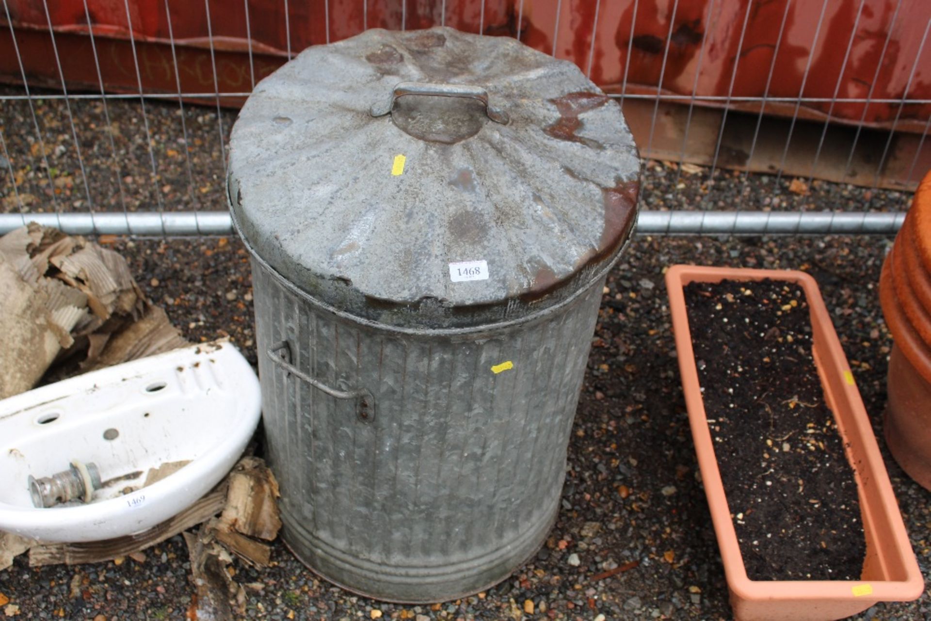 A galvanised dust bin and lid