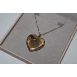 A 9ct gold front and back locket, hug to a fine li