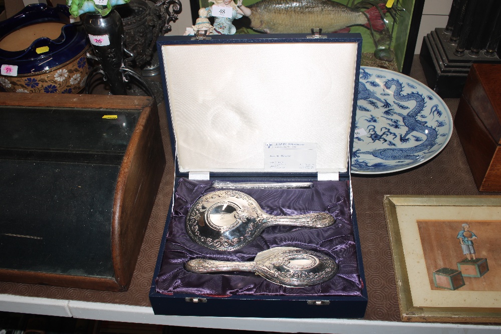 A silver dressing table mirror and brush set