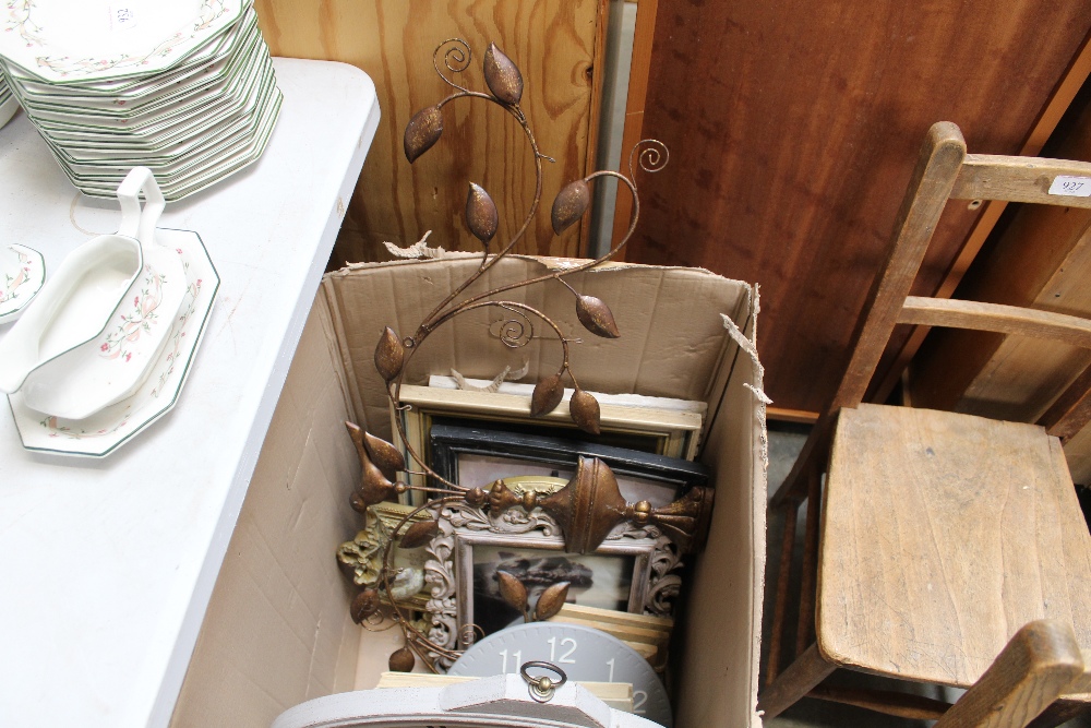 A box containing modern wall clocks, prints and fr