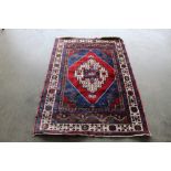An approx. 5'3" x 3'8" red and blue patterned rug