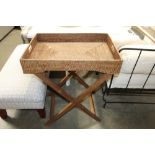 A wicker tray on folding stand