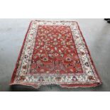 An approx. 6'8" x 4'5" red patterned rug AF
