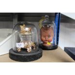 A dolls head under glass dome and a fairy decorate