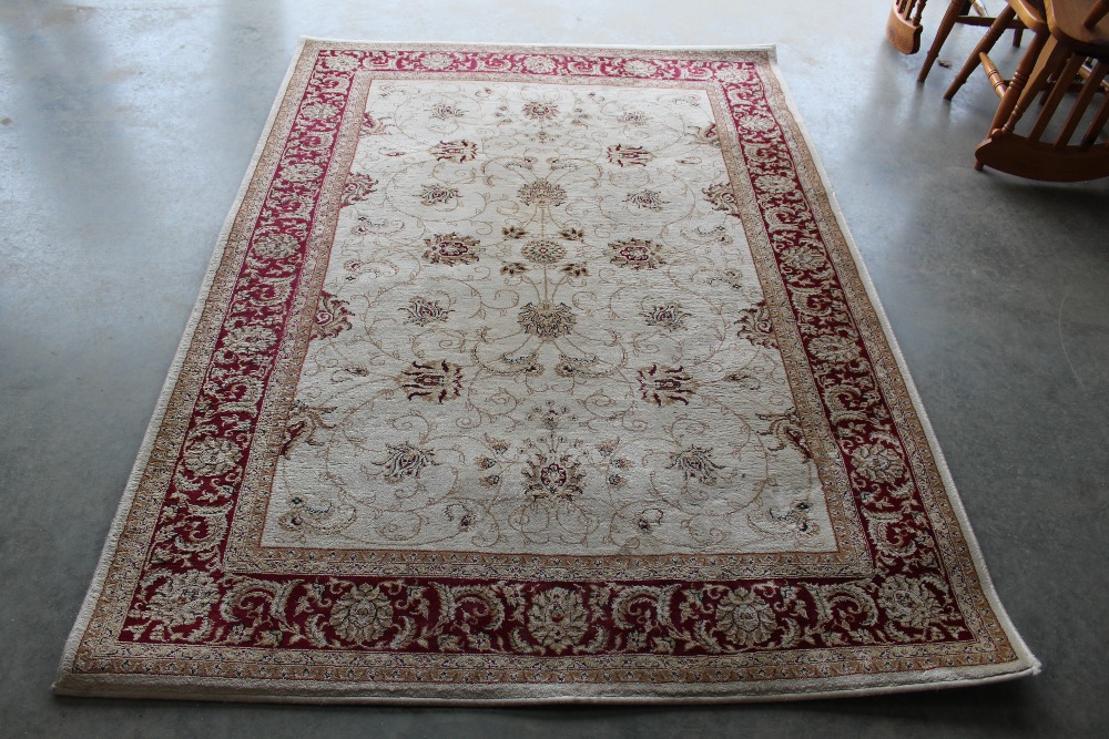 An approx. 7'6" x 5'3" red patterned rug