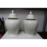 A pair of large white glazed vases and covers