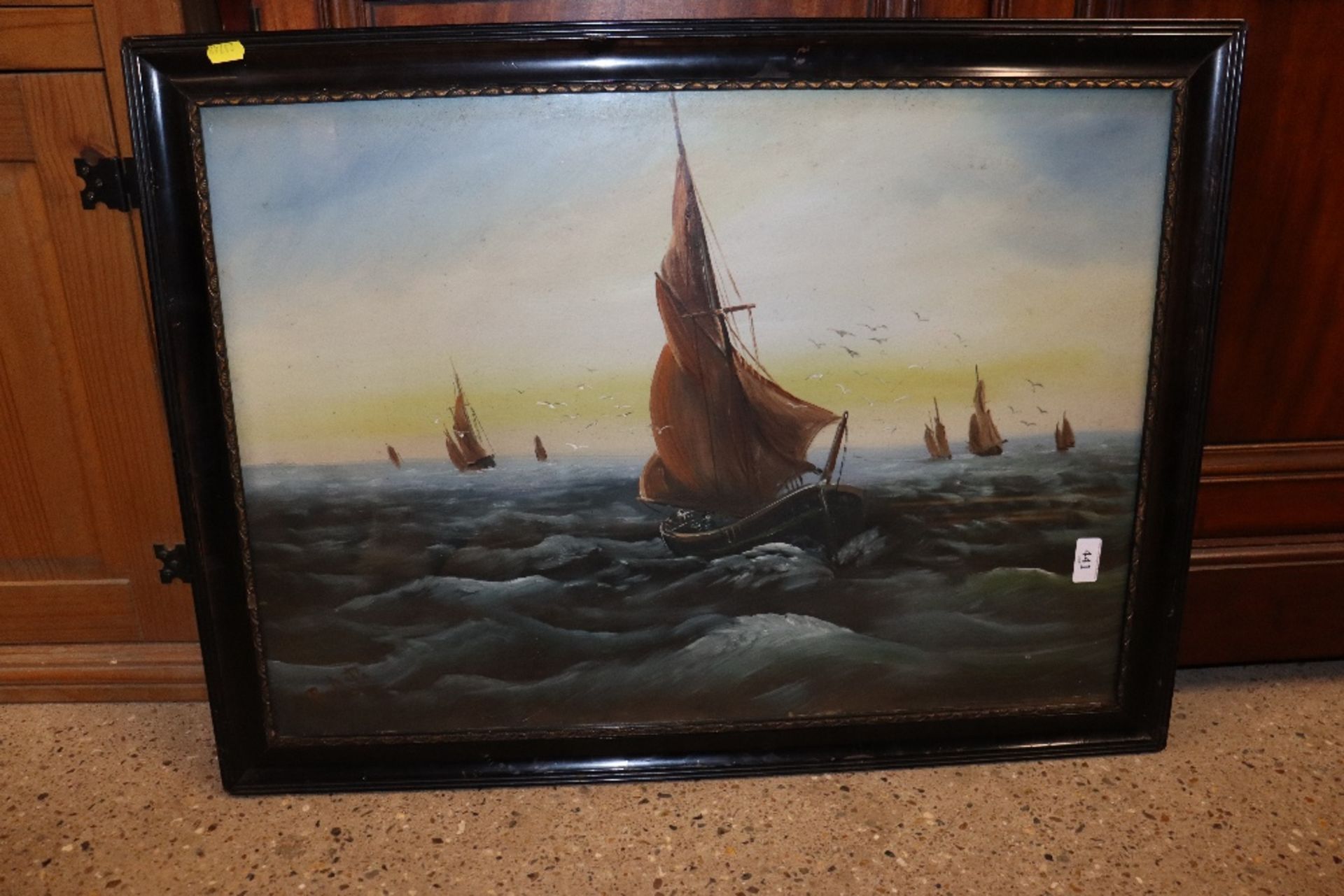 A framed and glazed oil depicting barges at sea, i