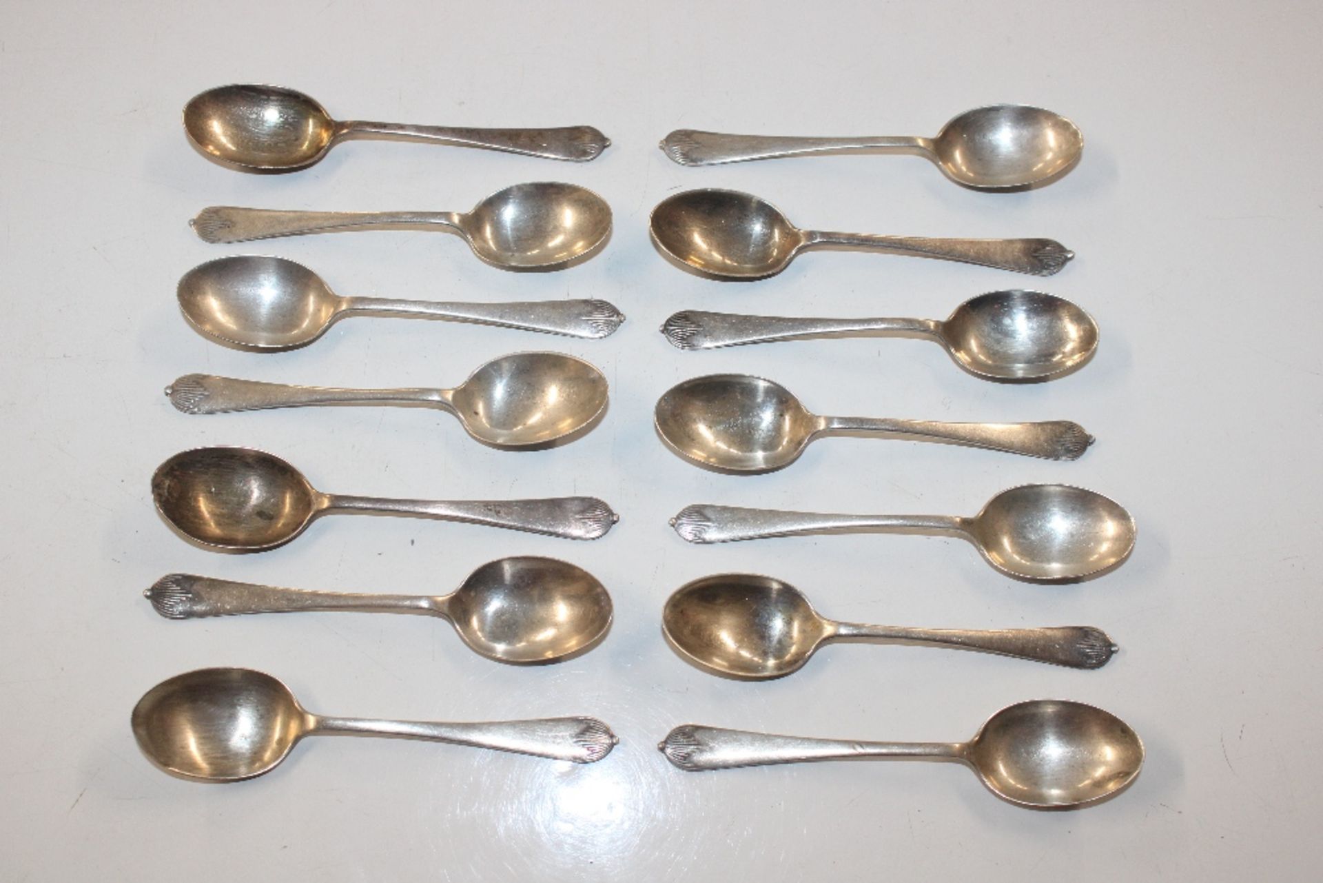 Fourteen silver teaspoons with engraving relating