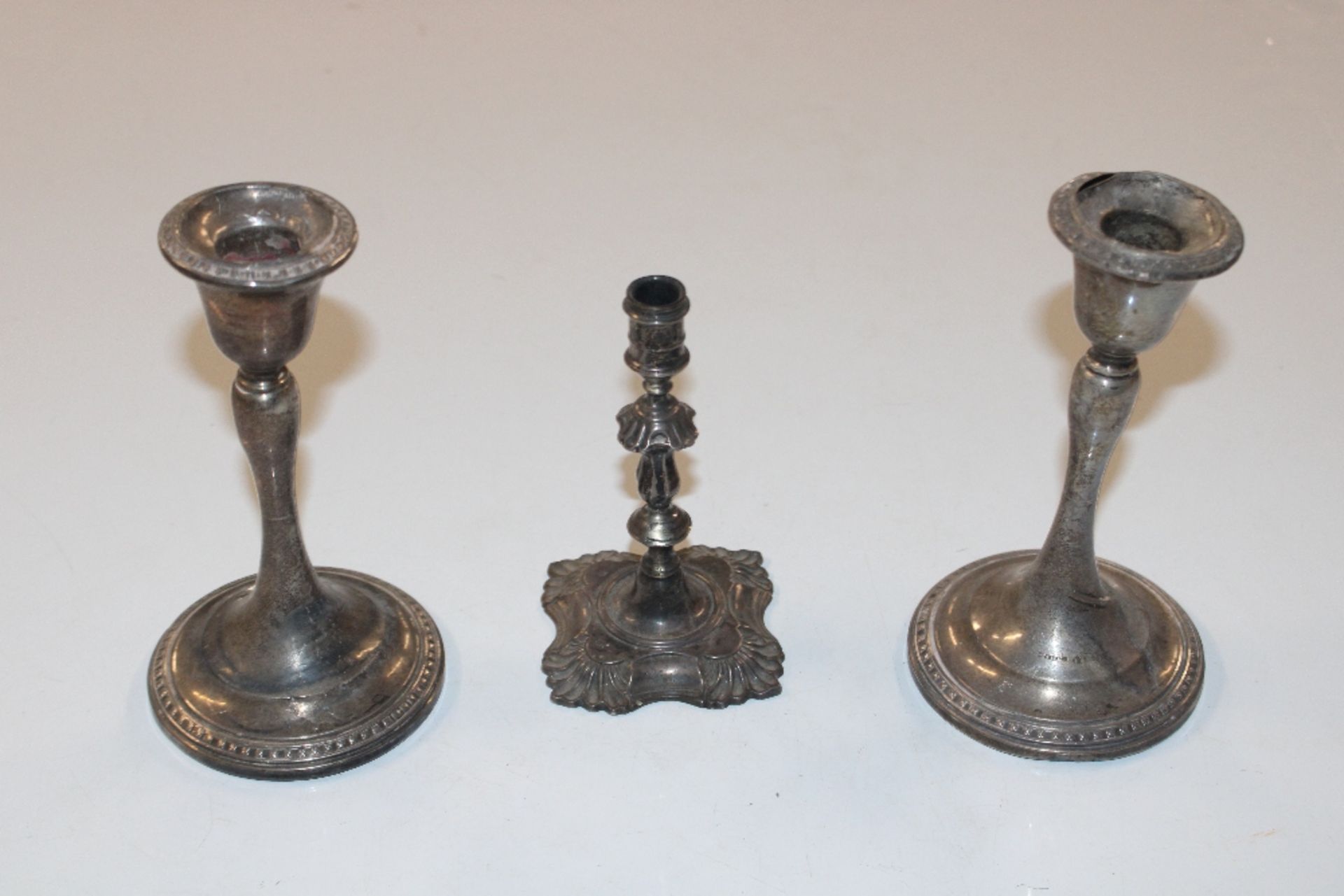 A pair of silver candlesticks with weighted bases