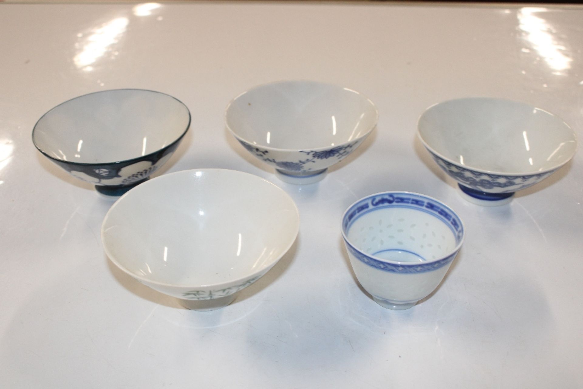 Four rice bowls; and a tea bowl with two character