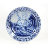 A Delft charger decorated with a scene of seated f