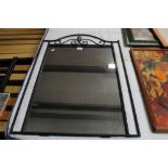 A wrought iron framed wall mirror