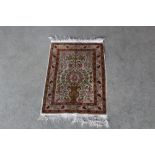 An approx. 2'6" x 1'6" floral patterned silk rug