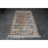 An approx. 6'10" x 3'10" blue patterned rug