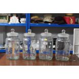 Four glass storage jars