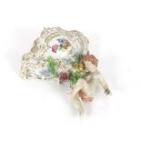 A continental porcelain cherub decorated wall pocket; four blanc de chine cherub ornaments and an