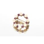 A 9ct gold circular brooch mounted pearls and amethyst coloured stones