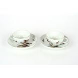 A pair of mid-18th Century Meissen porcelain ornithological cups and saucers, decorated birds on